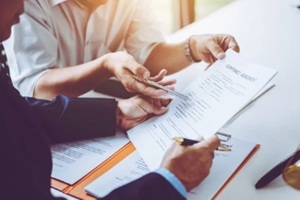 group of middle age Asian business people and lawyers discussing and sign a contract