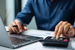 close up businessman hand using calculator to budgeting and tax calculation monthly expenses