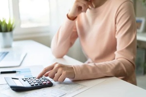 debt asian young woman hand using calculator to calculating money balance from bill and income