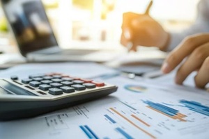 auditor and accountant team collaborating in an office analyzing financial data and accounting records with a calculator