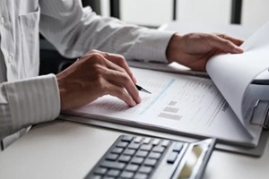 financial admin reviewing printed data at worktable in professional office